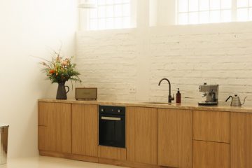 A kitchen with a stove, sink, and cabinets