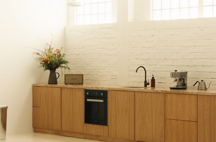 A kitchen with a stove, sink, and cabinets